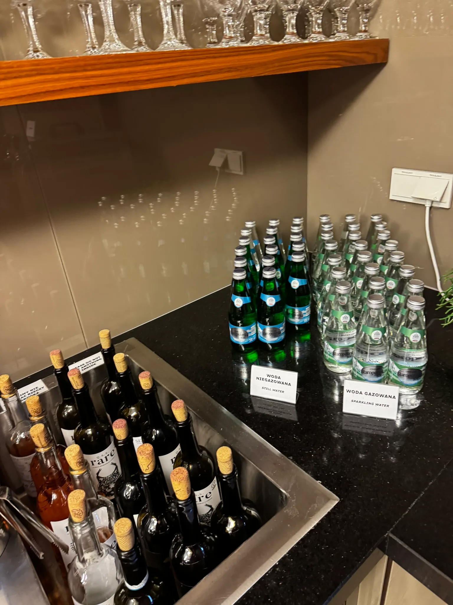 Flaschen mit Wasser und Wein auf einem Tisch in einer Lounge