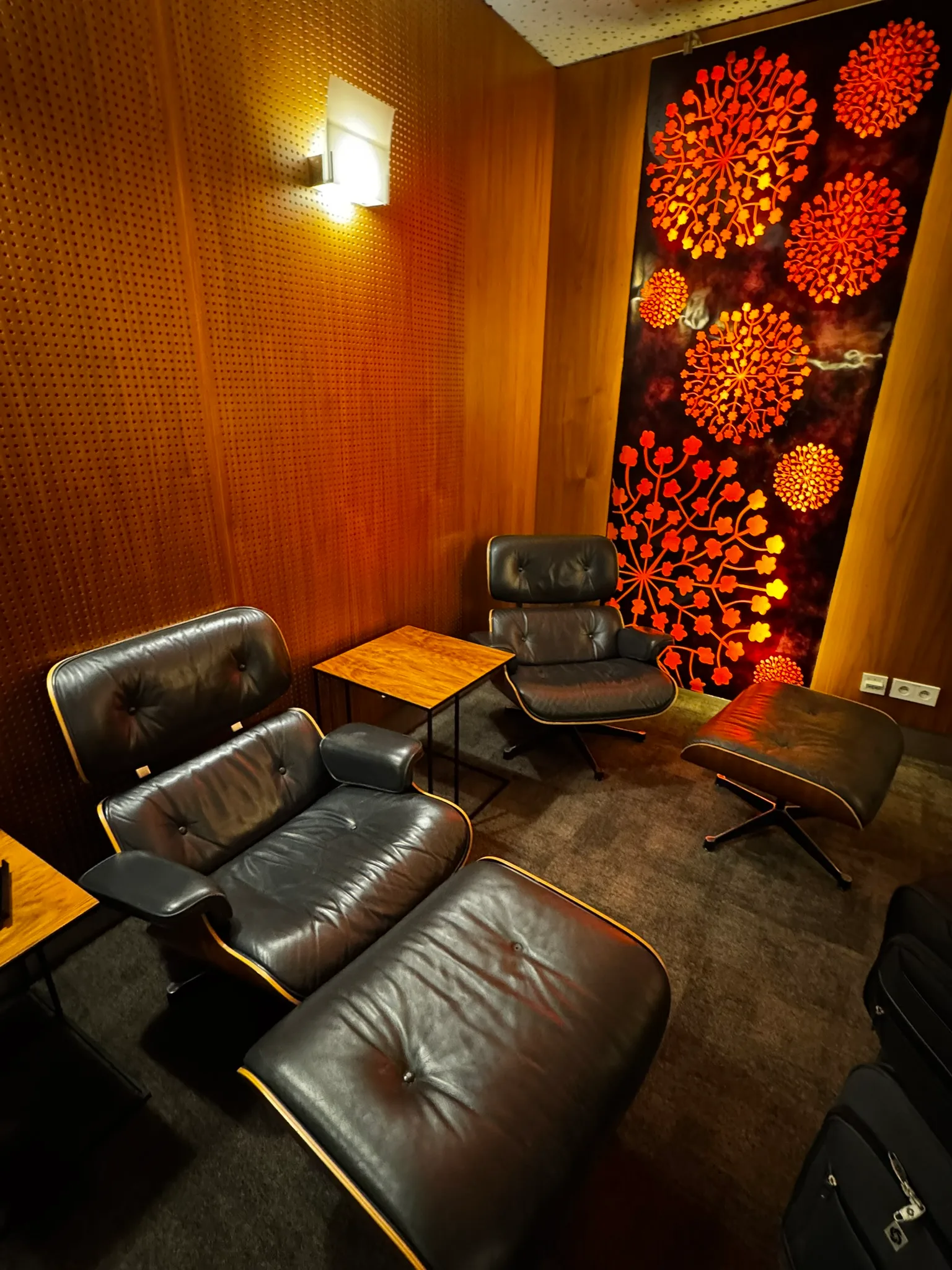 Lounge mit schwarzen Ledersesseln und Holztisch
