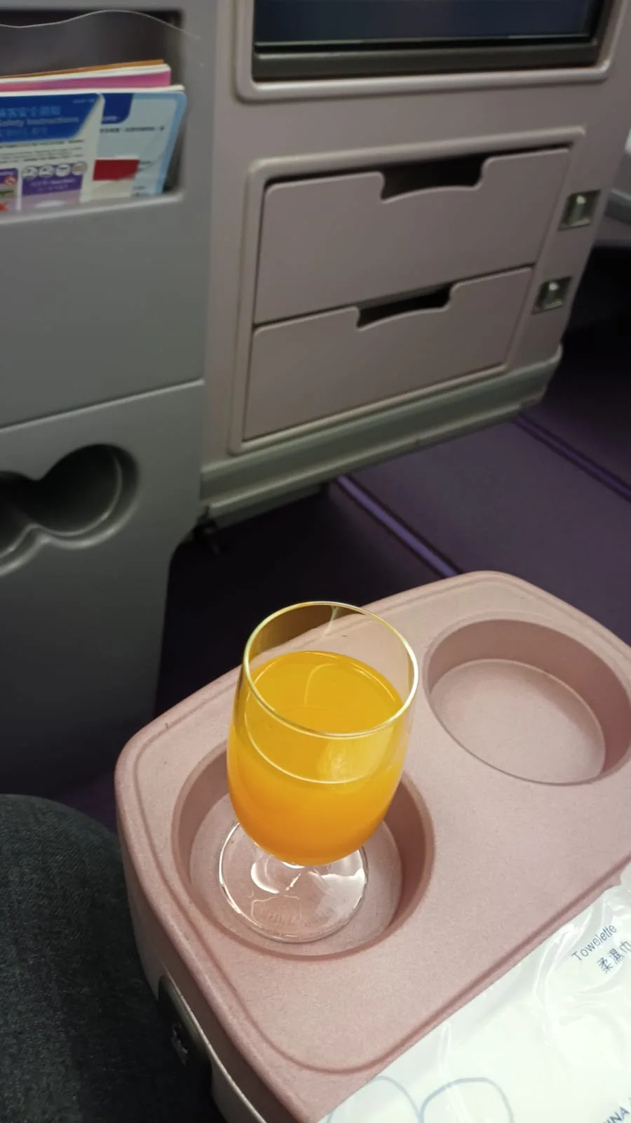 Glas Orangensaft auf Flugzeugtisch