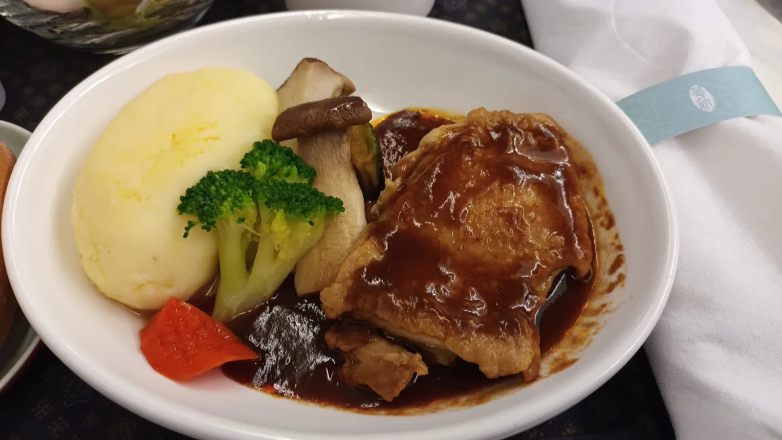 Gefüllter Teller mit Hühnchen in Soße, Kartoffelpüree, Brokkoli und Pilzen