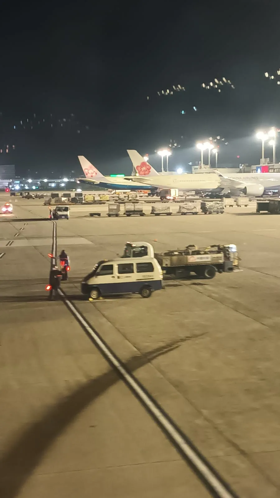 Flughafen bei Nacht mit Flugzeugen und Flugzeugtransportfahrzeugen