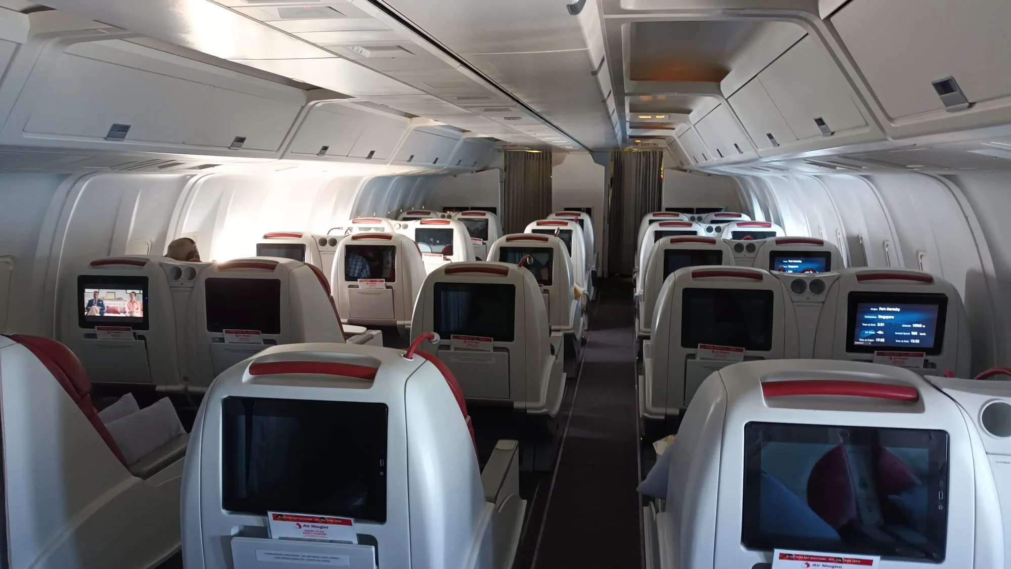 Flugzeugkabine mit Sitzen und Bildschirmen