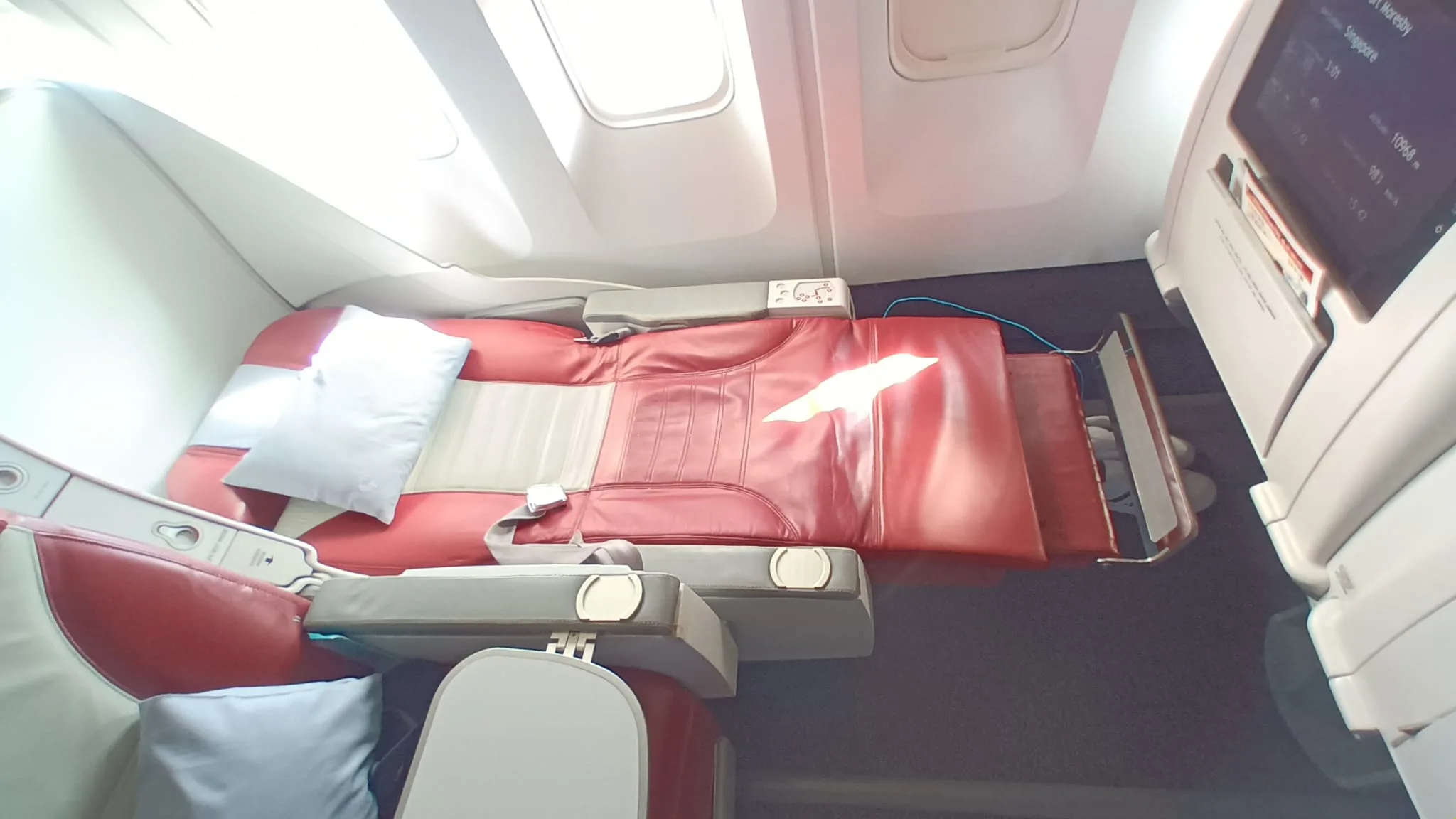Luxuriöses Business-Class-Sitz im Flugzeug mit gepolstertem Kopfteil und Kissen