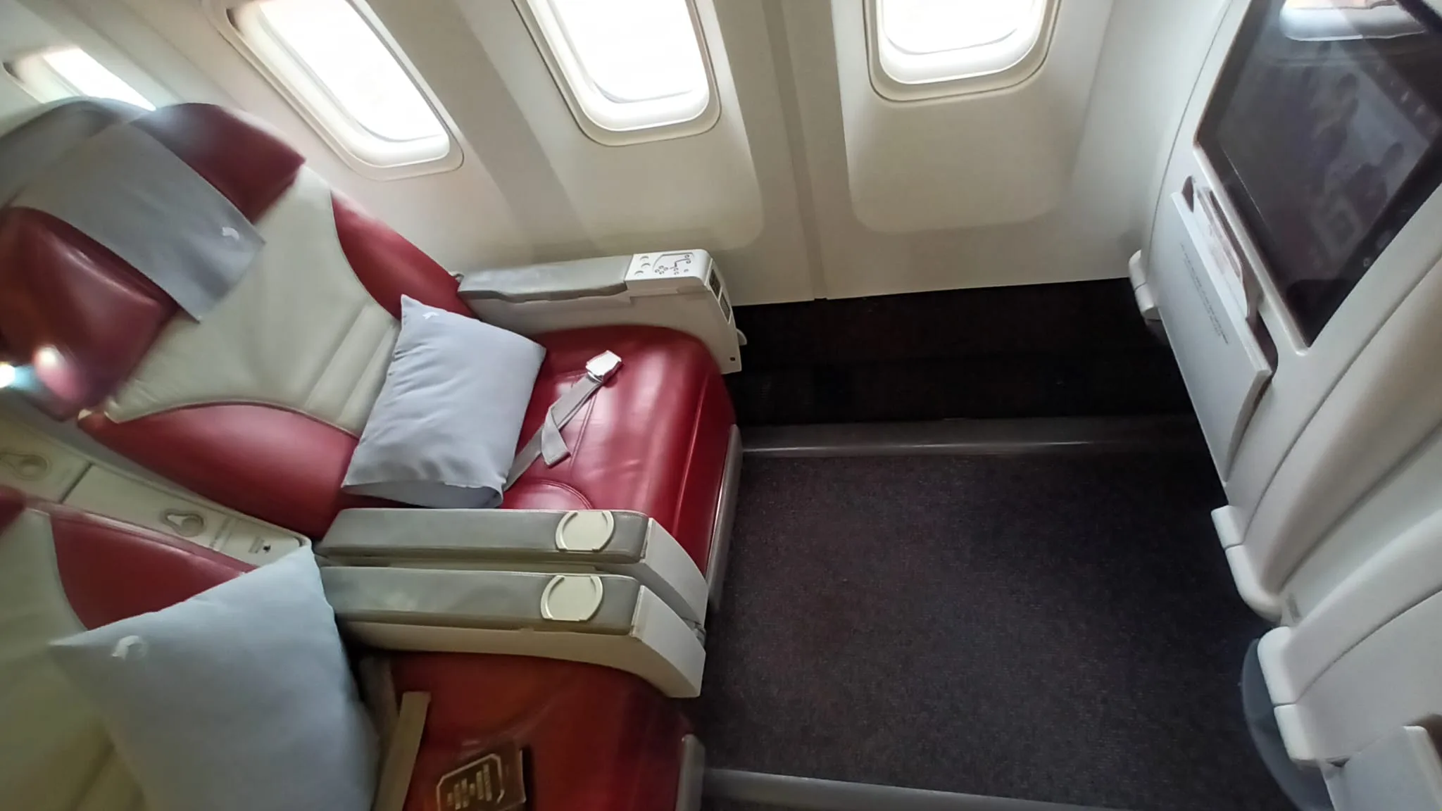 Luxuriöses Flugzeugkabineninnere mit roten Ledersitzen und Fenster