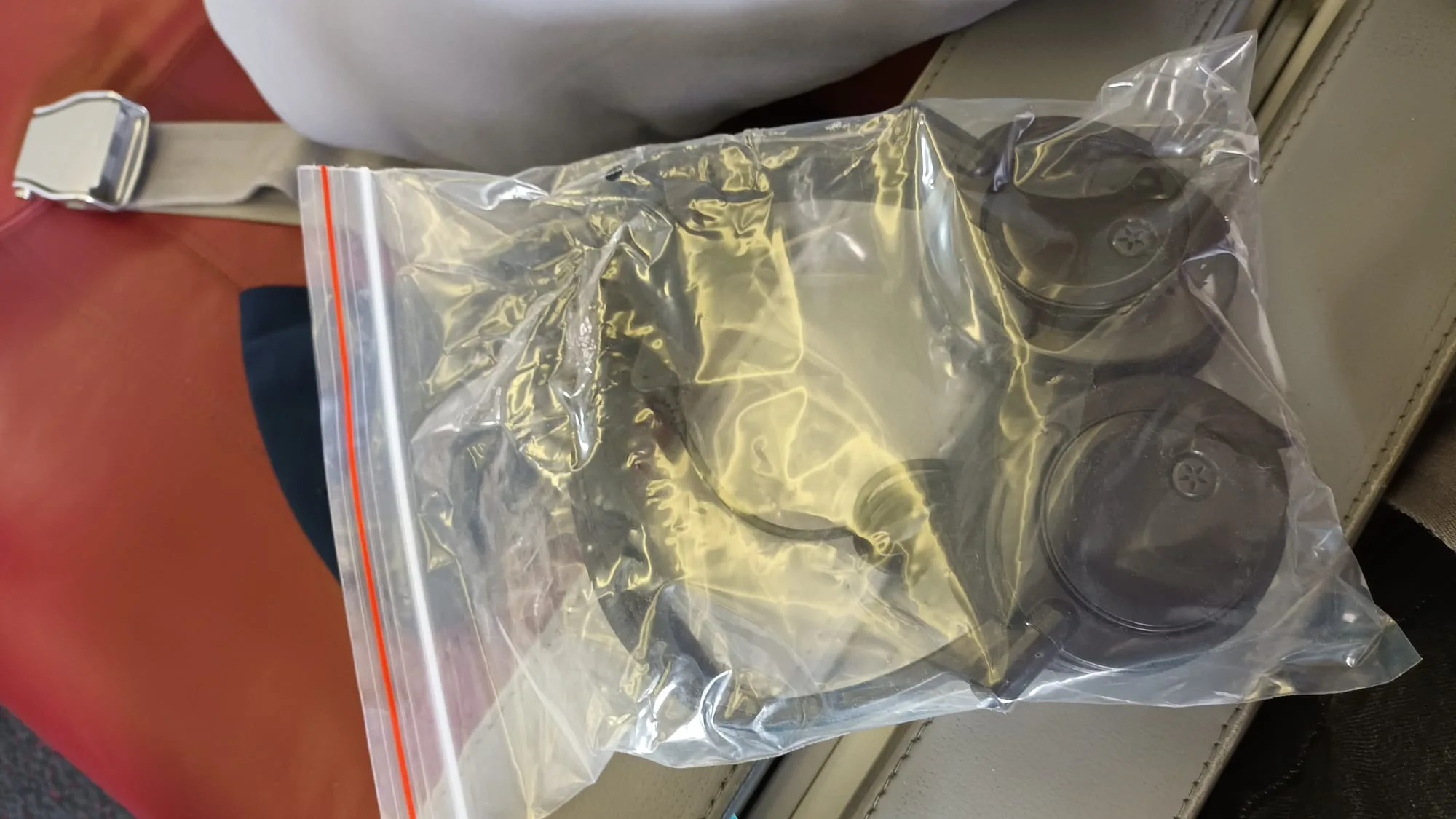 Flugzeug-Sicherheitsgurt mit Plastiktüte und Kopfhörer