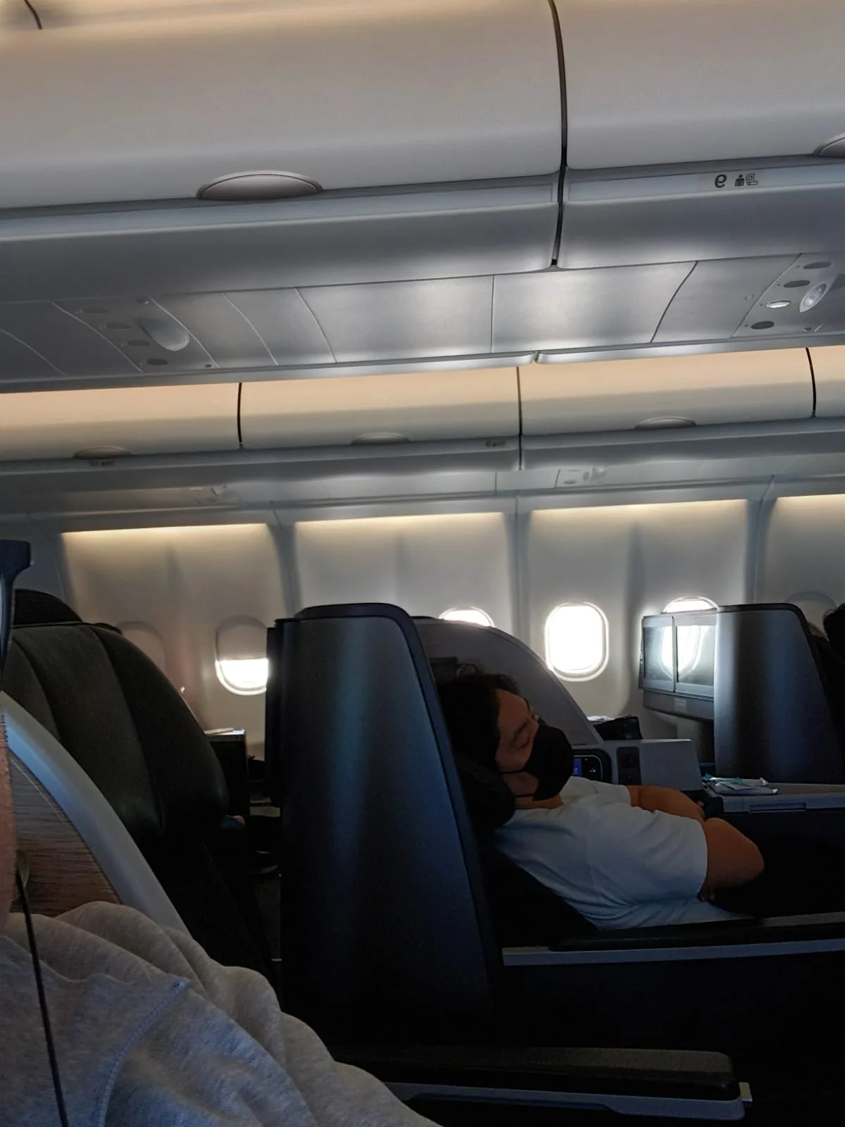 Passagier schläft in Business Class auf einem Flugzeug