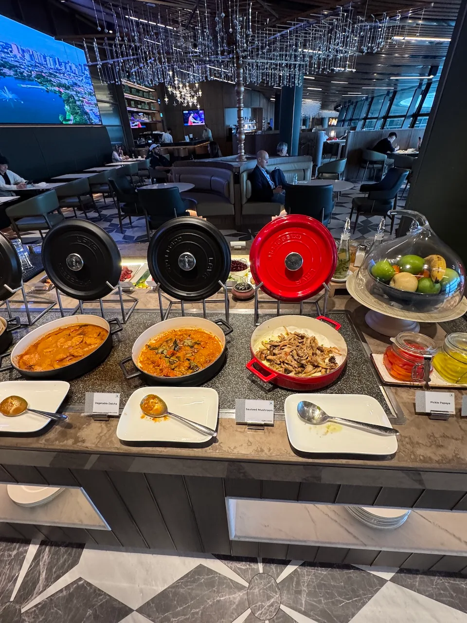 Buffet mit verschiedenen Gerichten und Obstschale im Flughafenlounge
