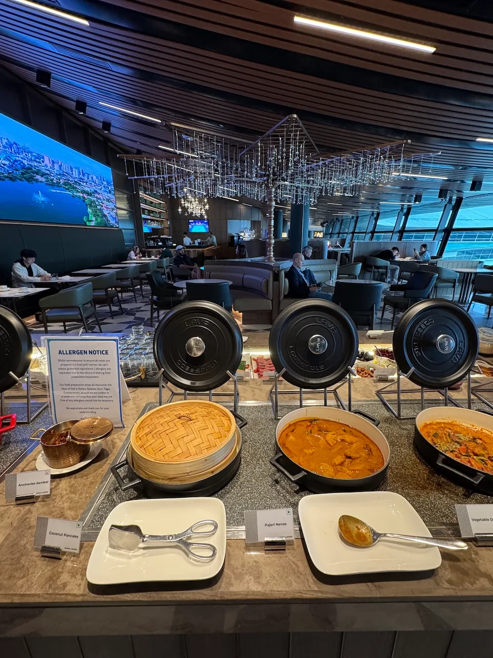 Buffet mit verschiedenen Gerichten und Kochtopfen im Flughafenlounge