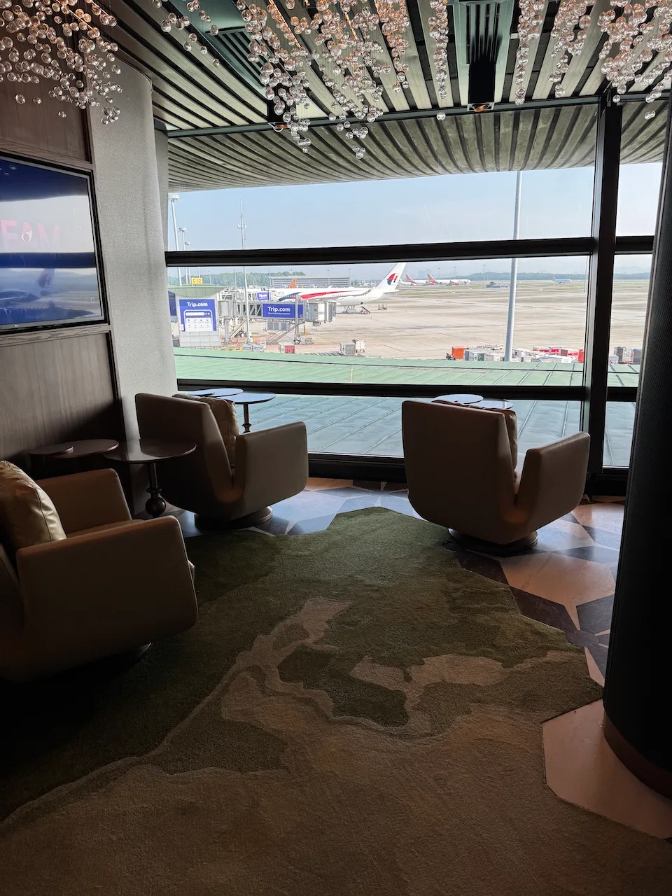 Lounge mit Sesseln und Blick auf Flughafen