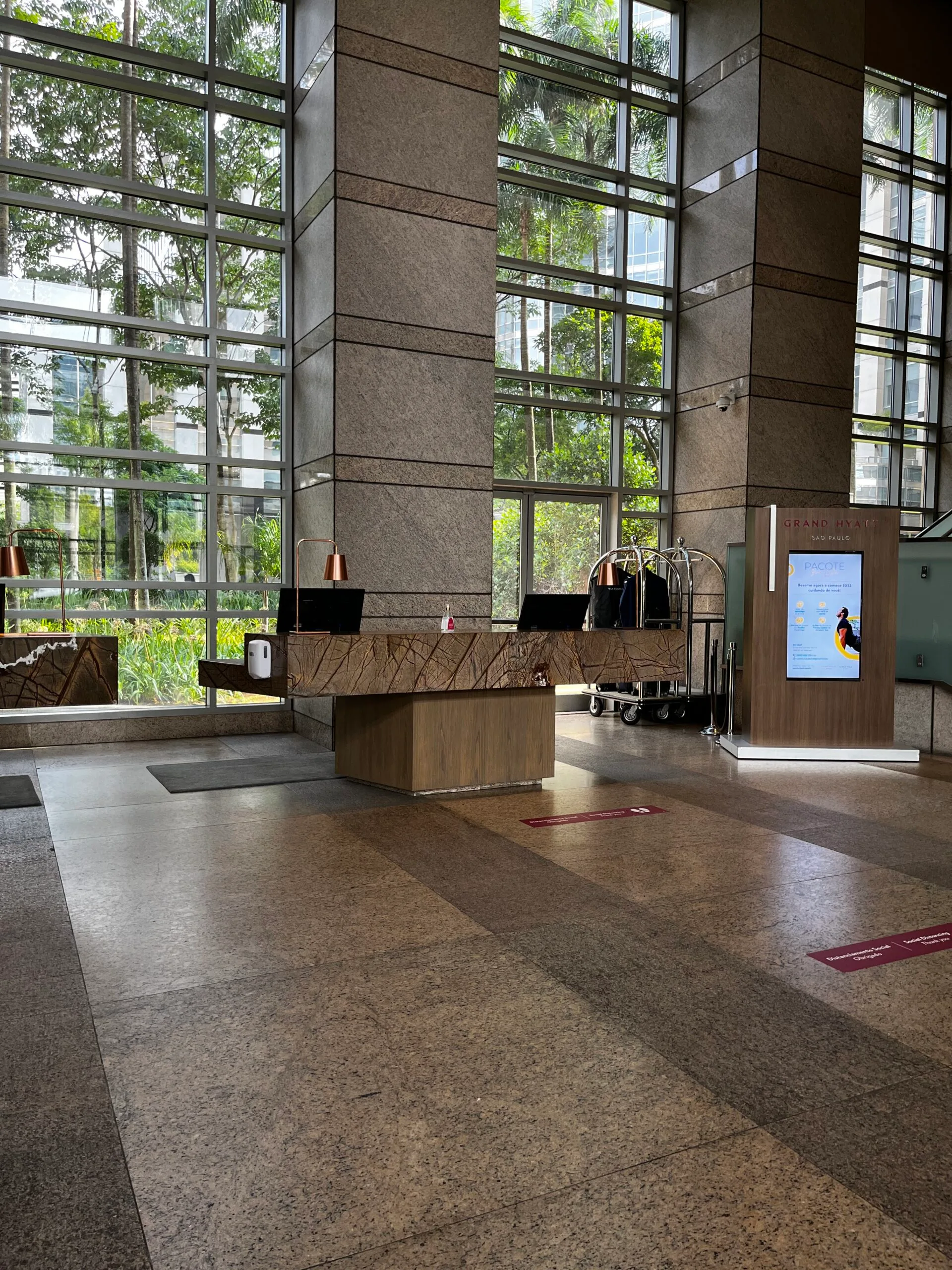 Hotellobby mit Empfangsdesk und großen Fenstern