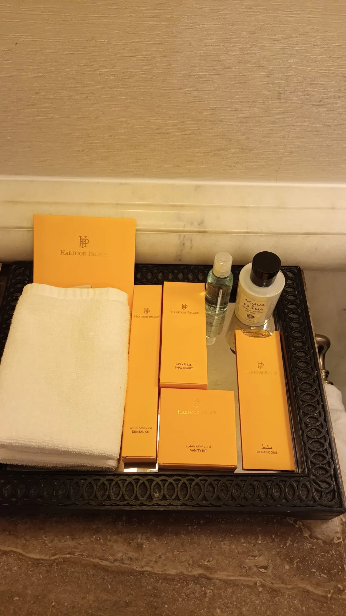 Hotelzubehör auf Tablett mit Handtuch und Kosmetikprodukten