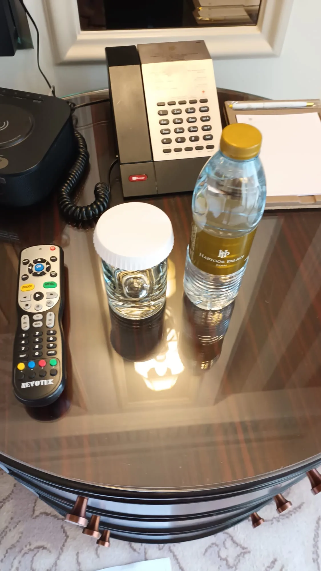 Hotelzimmer mit Fernbedienung, Telefon und Wasserflaschen auf Nachttisch