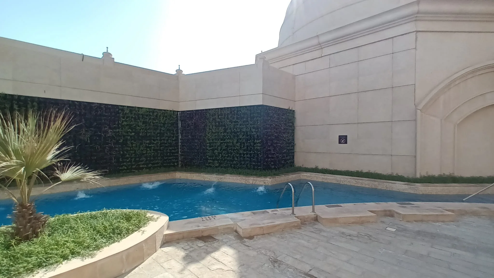 Außenbereich mit Pool und grüner Wand
