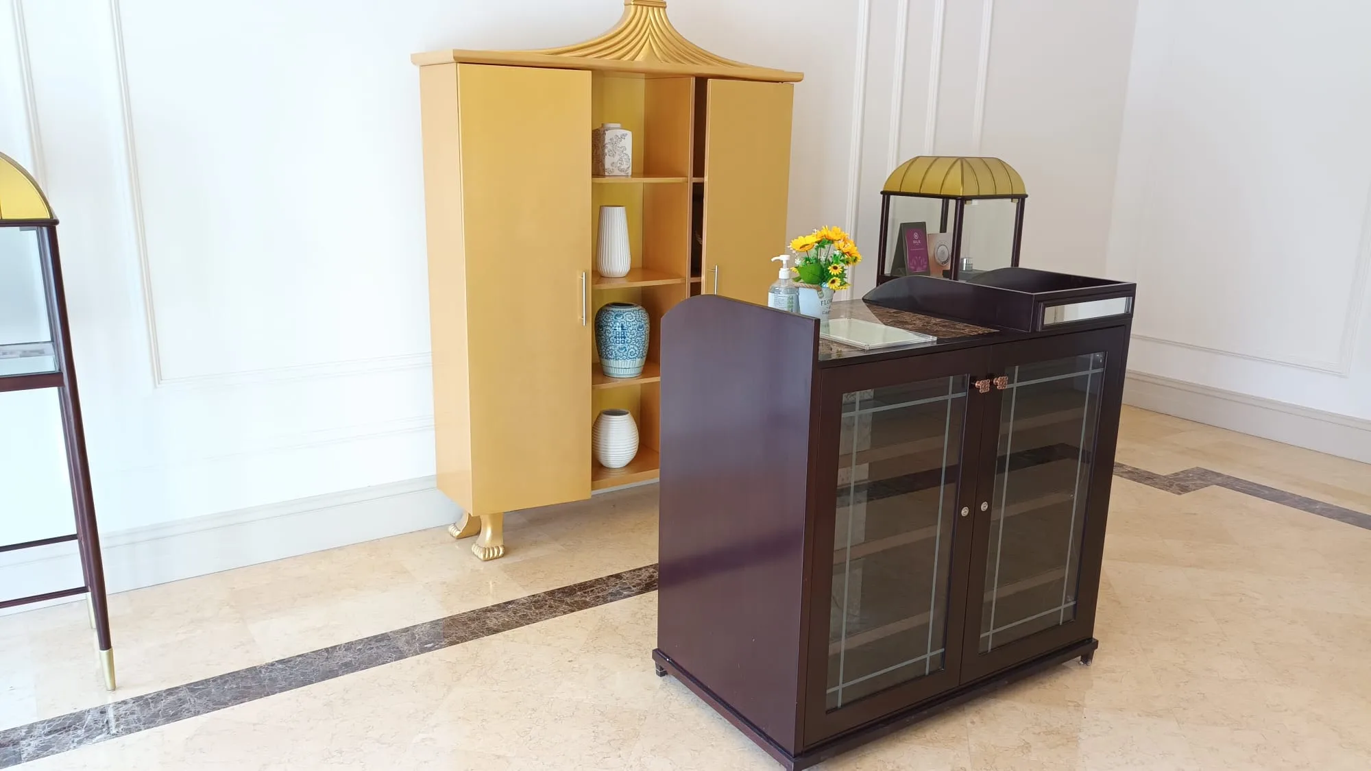 Hotellobby mit goldenem Schrank und dunklem Sideboard