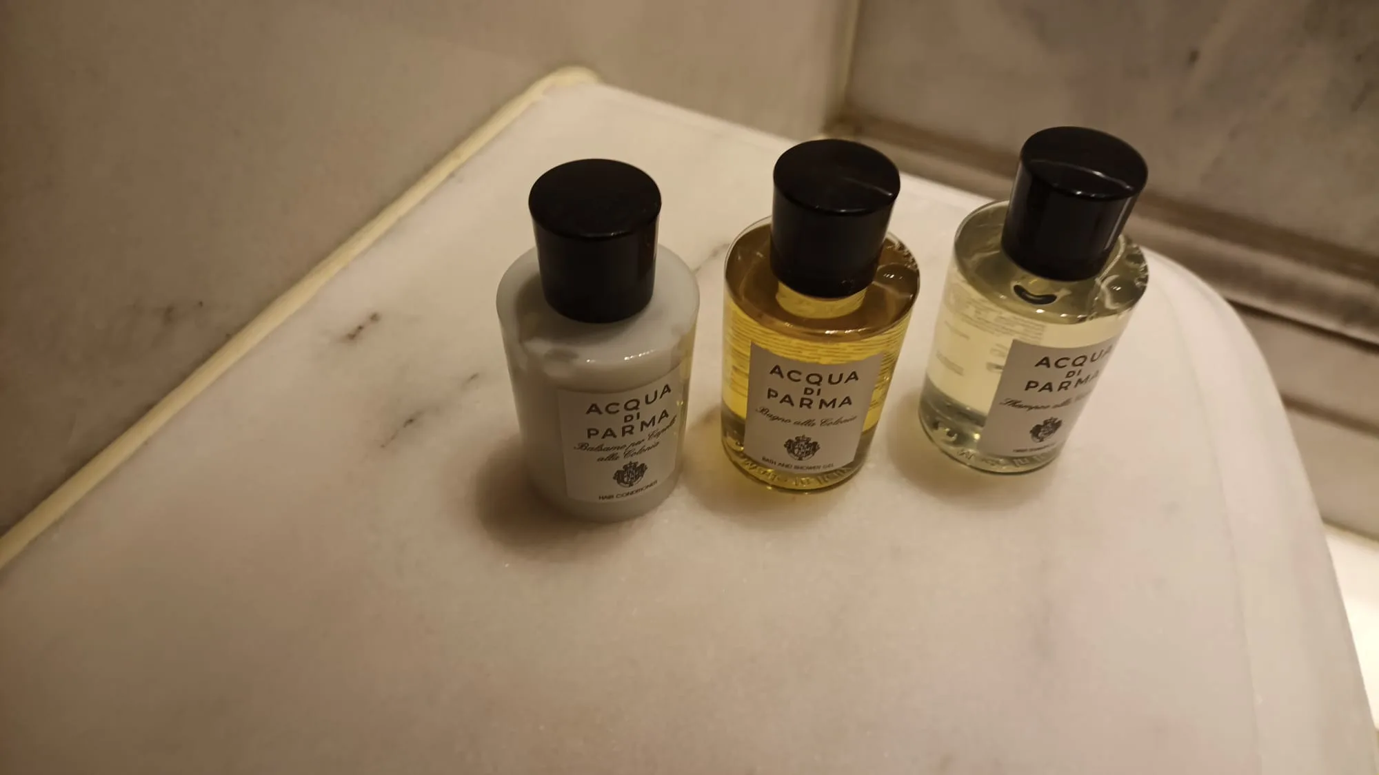 Drei Flaschen Acqua di Parma Kosmetikprodukte auf Marmorplatte