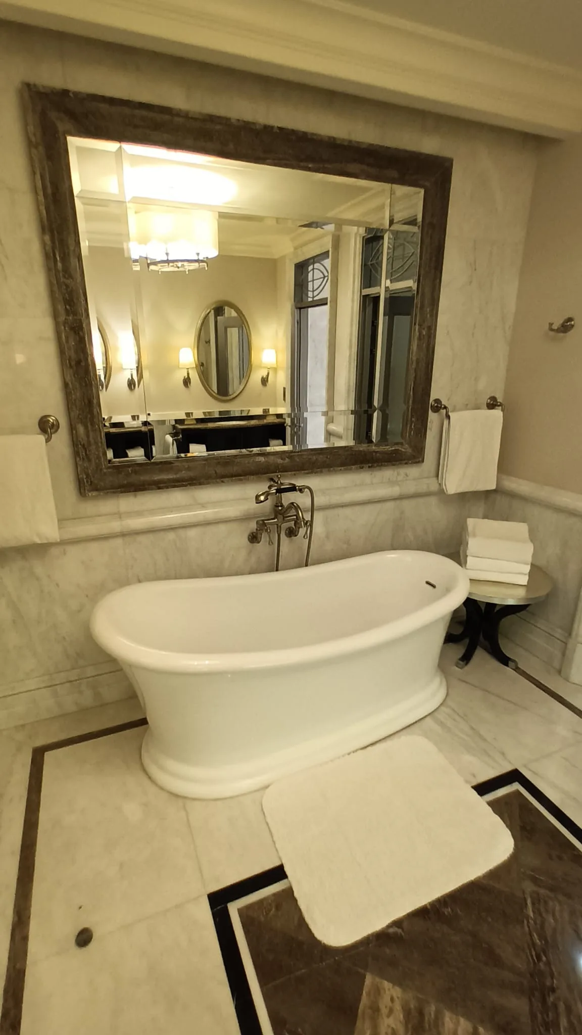Freistehende Badewanne mit Spiegel und Handtuchhalter im Luxushotel