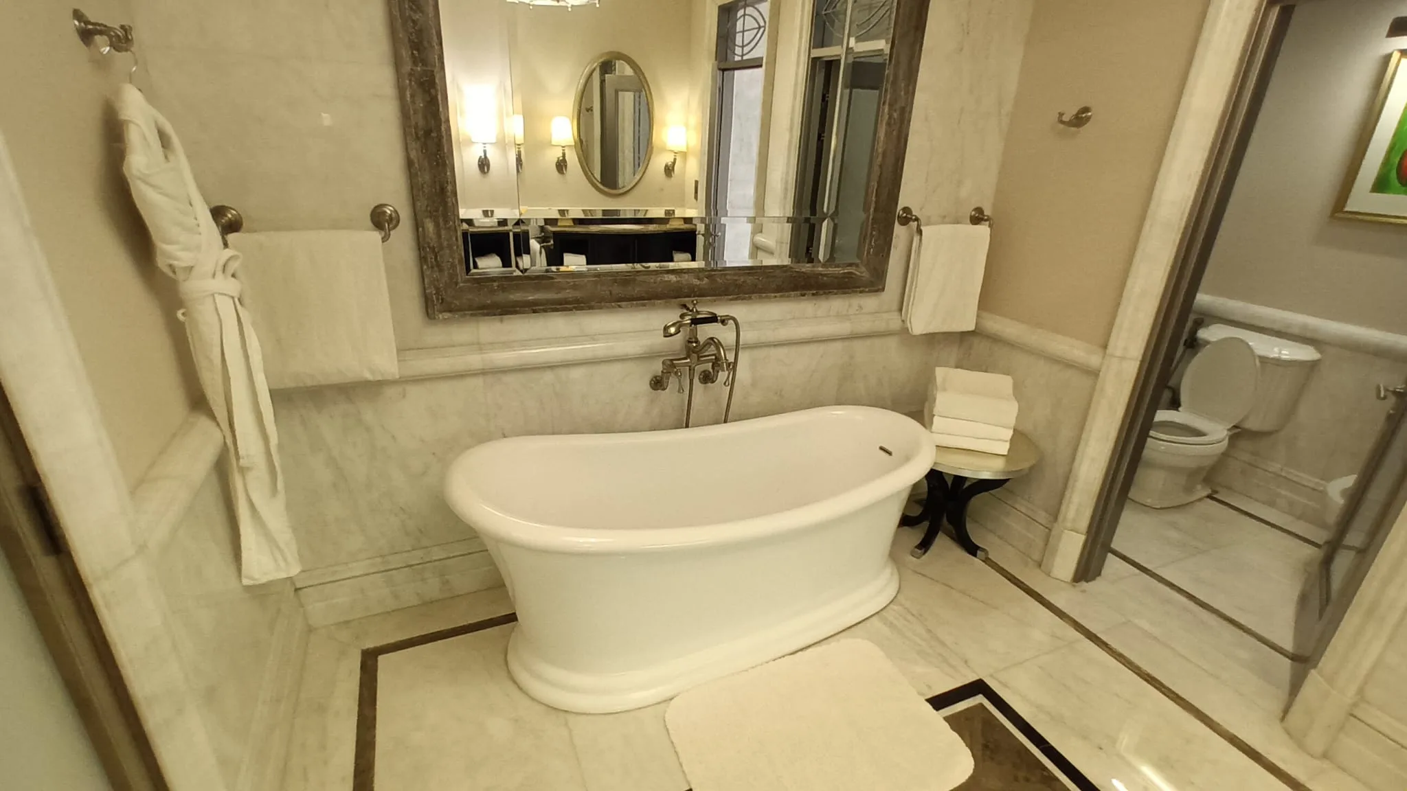 Badezimmer mit freistehender Badewanne und großem Spiegel