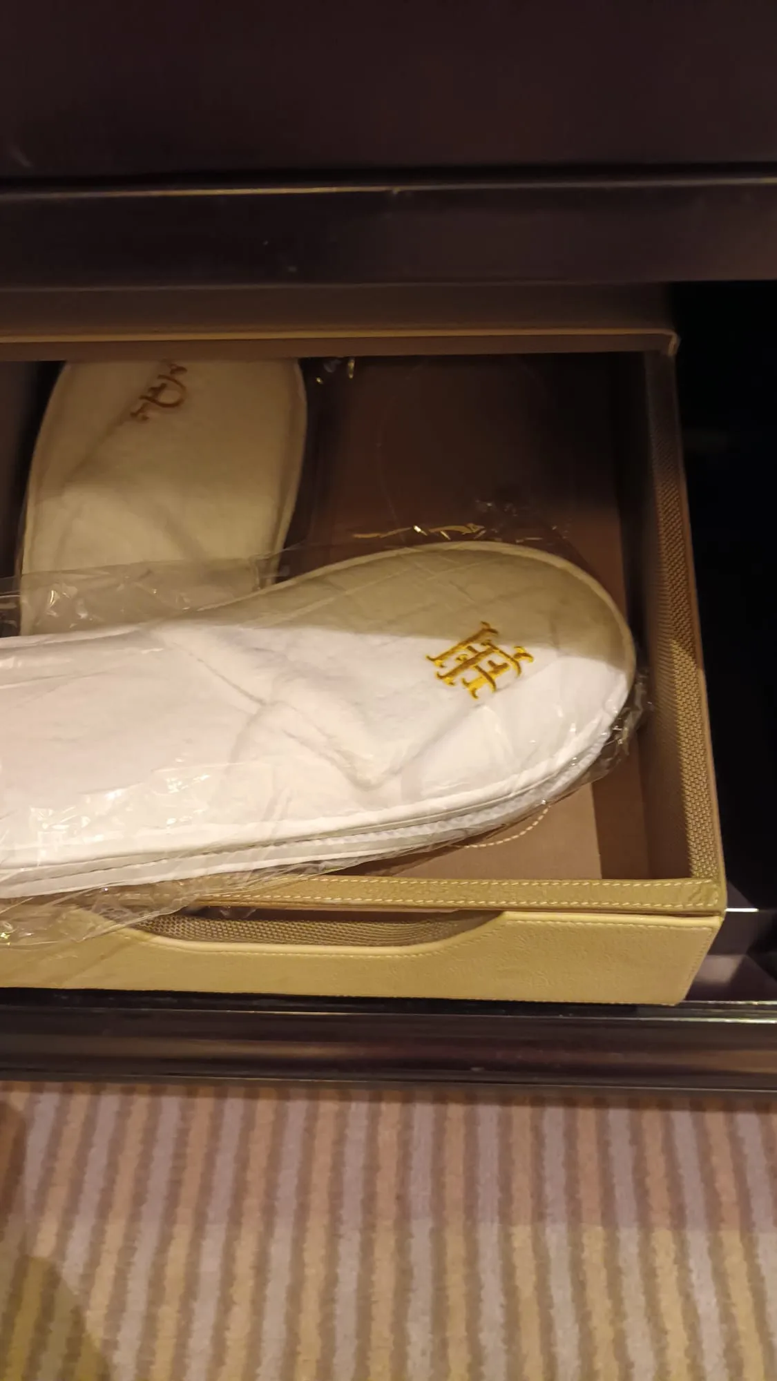 Weißer Schuh mit Initialen in Gold auf offenem Schublade