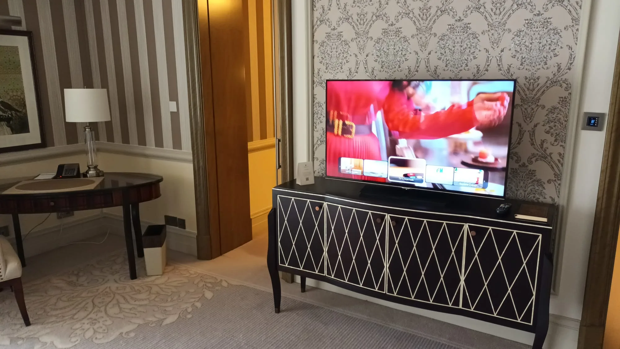 Hotelzimmer mit TV auf schwarzem Sideboard