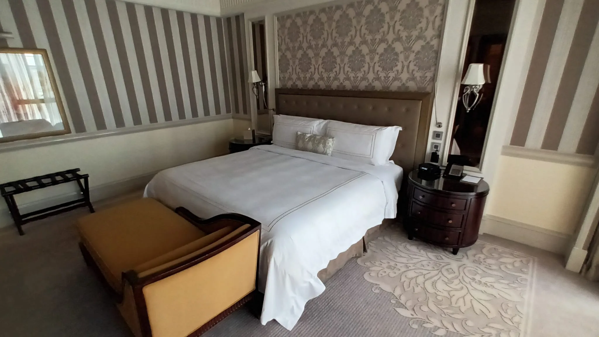 Hotelzimmer mit Doppelbett und Teppich im Wohnbereich