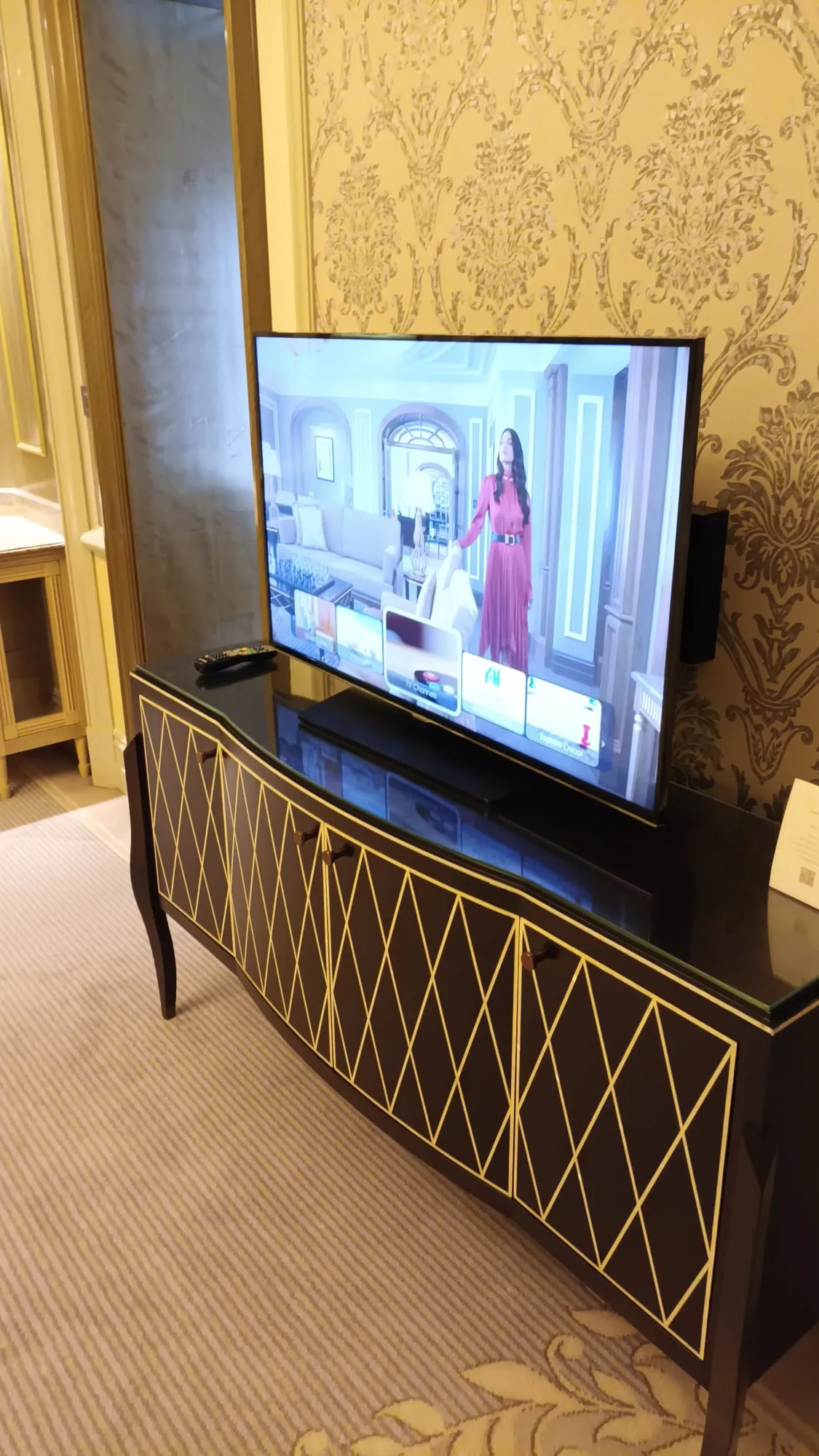 Hotelzimmer mit Fernseher auf schwarzem Sideboard