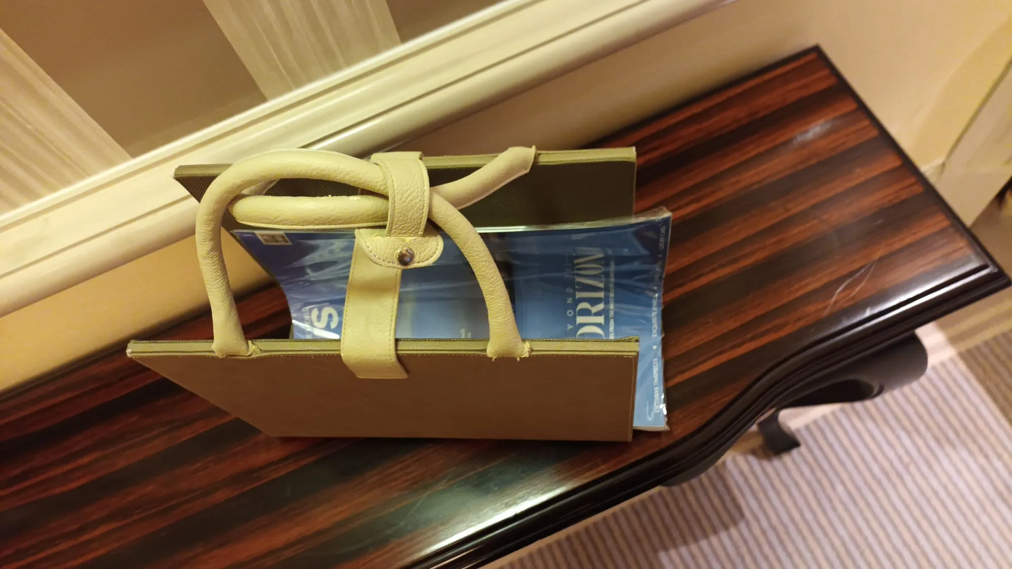 Gelbe Handtasche auf Holztisch mit Buch