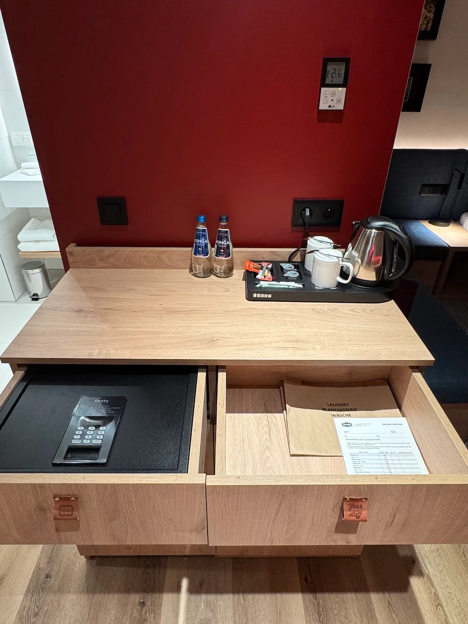 Holztisch mit Kaffeemaschine und Getränken im Hotelzimmer