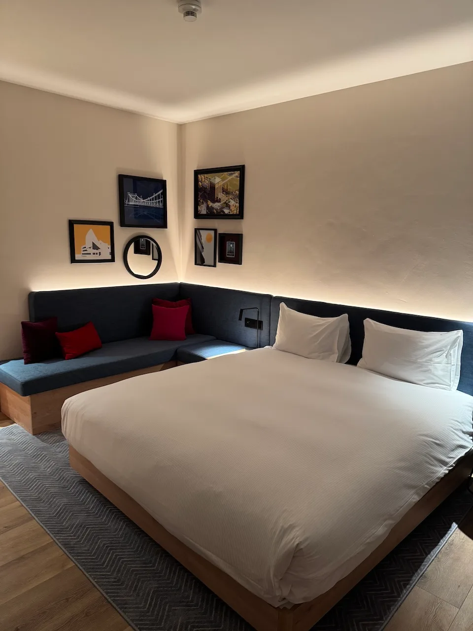 Hotelzimmer mit Doppelbett und Kissen in Grautönen