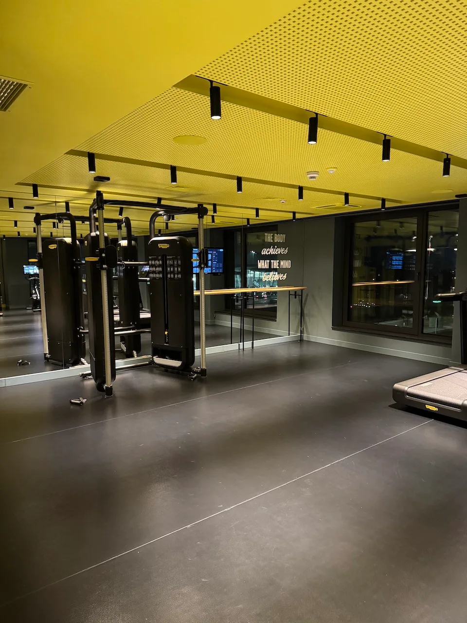 Fitnessraum mit Maschinen und Spiegeln