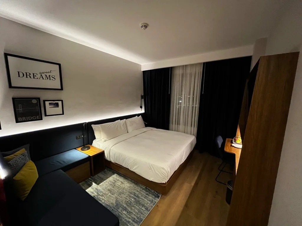 Hotelzimmer mit Doppelbett und Wandbild