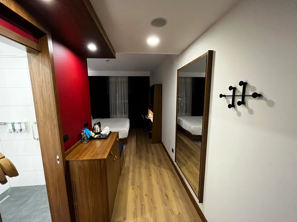 Hotelzimmer mit Doppelbett und Holzmöbeln