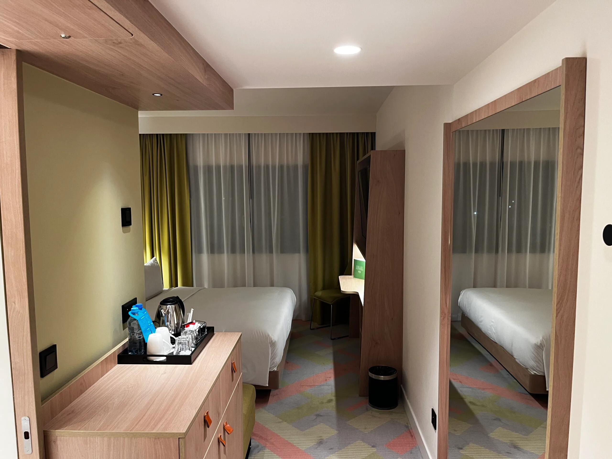 Hotelzimmer mit Doppelbett und Schreibtisch in neutralen Farben