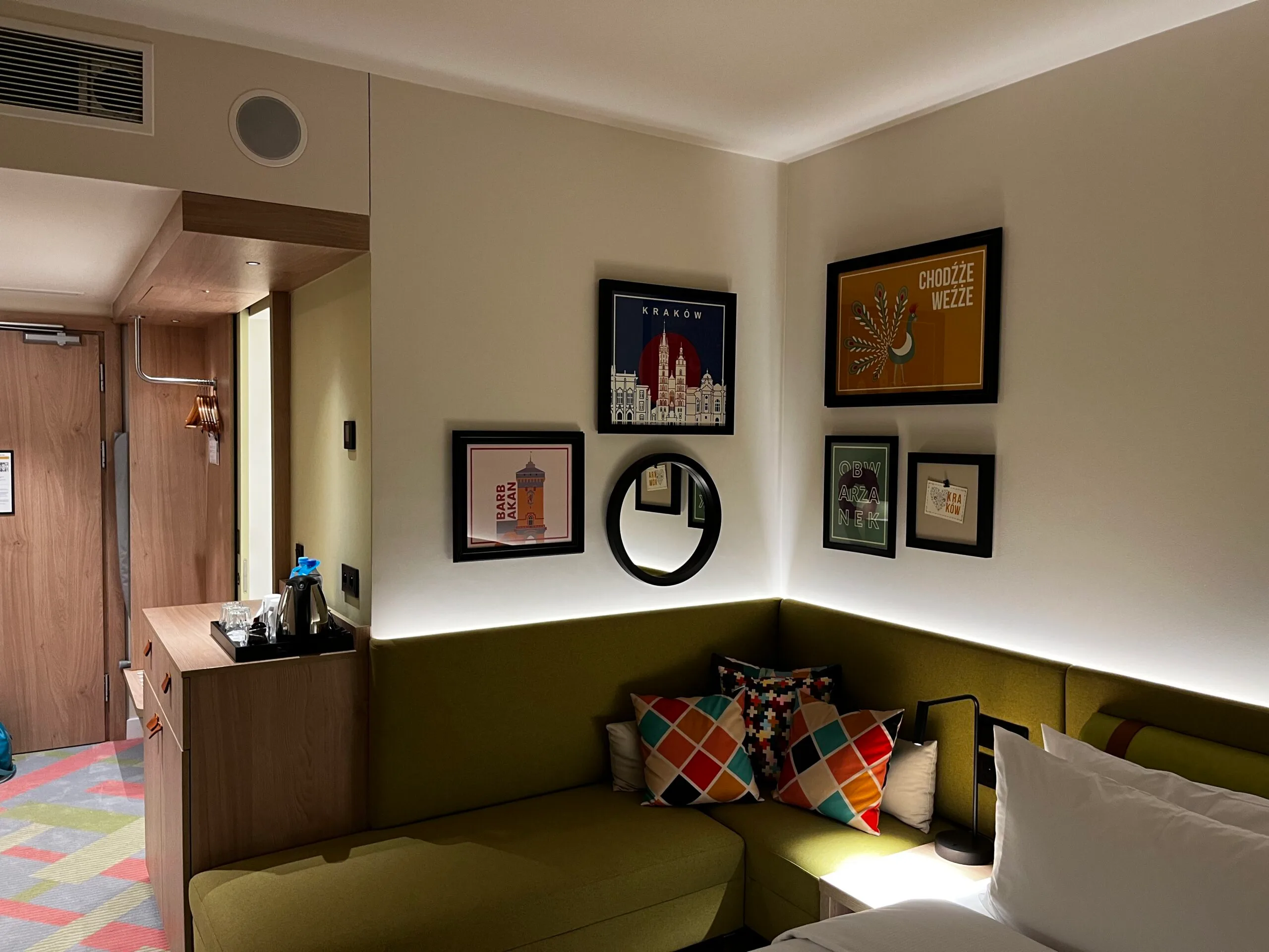 Hotelzimmer mit grüner Bank und dekorativen Kissen