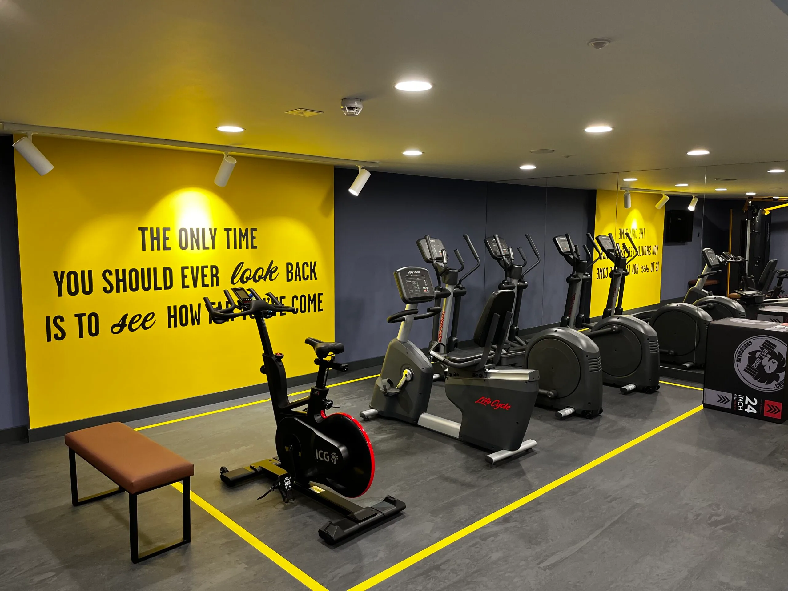 Fitnessraum mit Stationärrädern und Motivwand