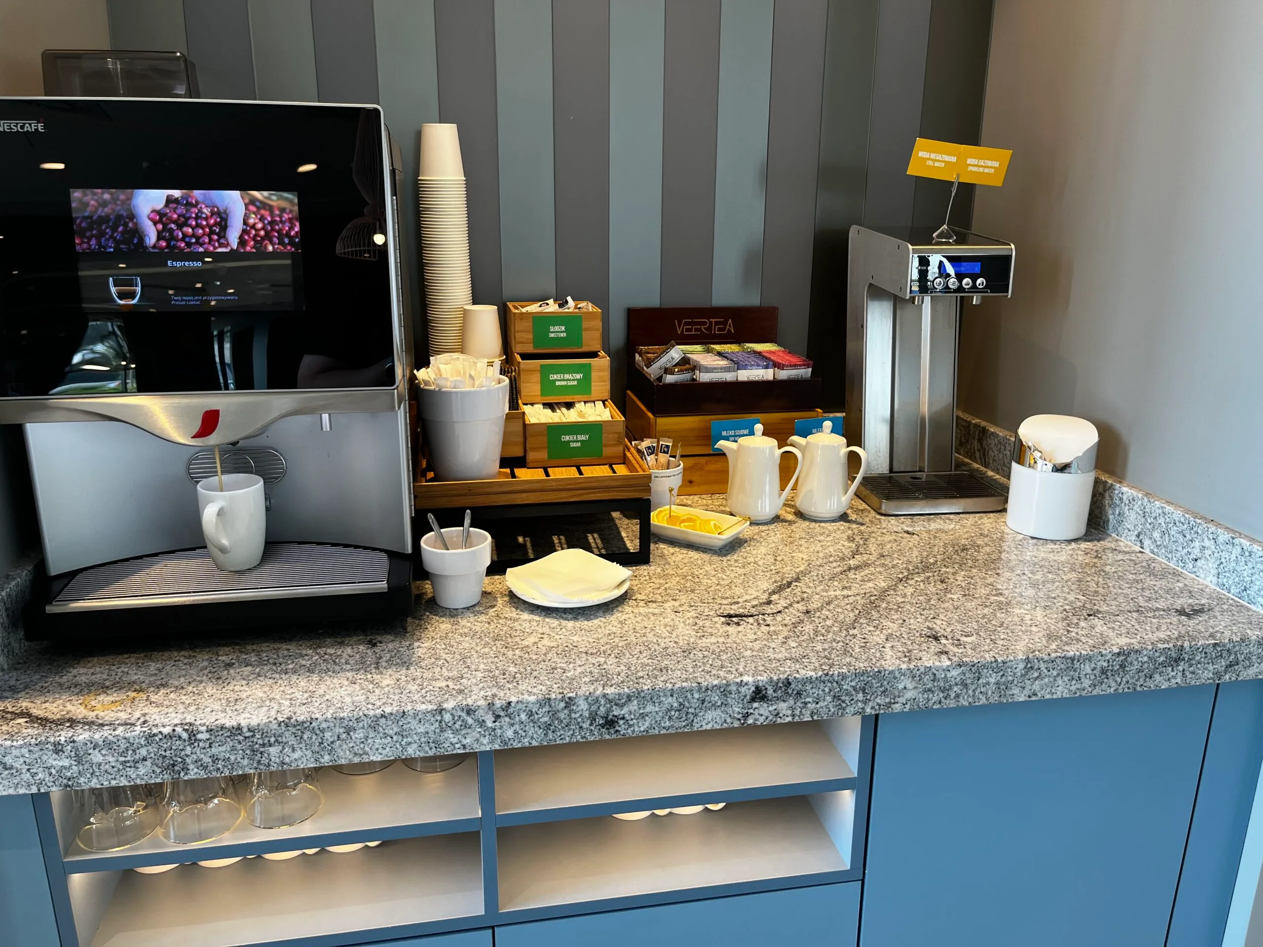 Kaffeeautomat und Teebereich im Hotel mit Kaffeetassen und Teekannen