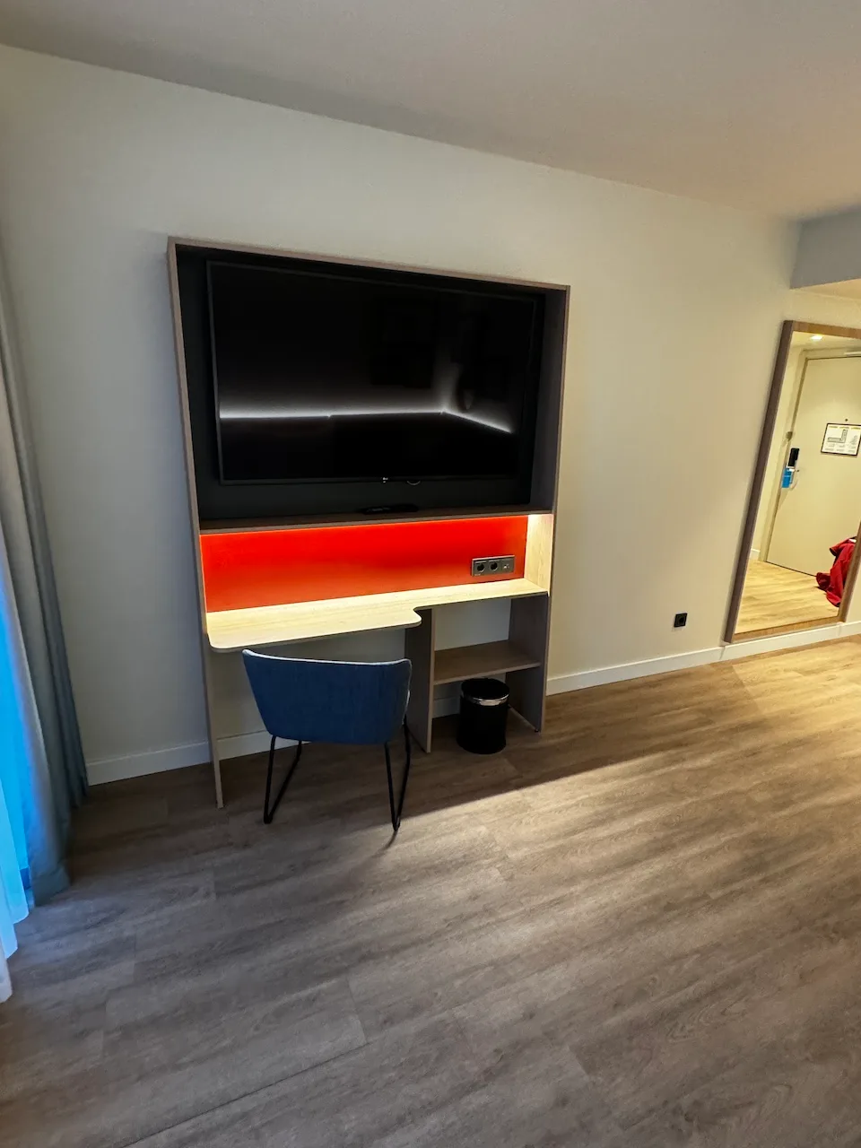 Hotelzimmer mit Schreibtisch und Fernseher an der Wand