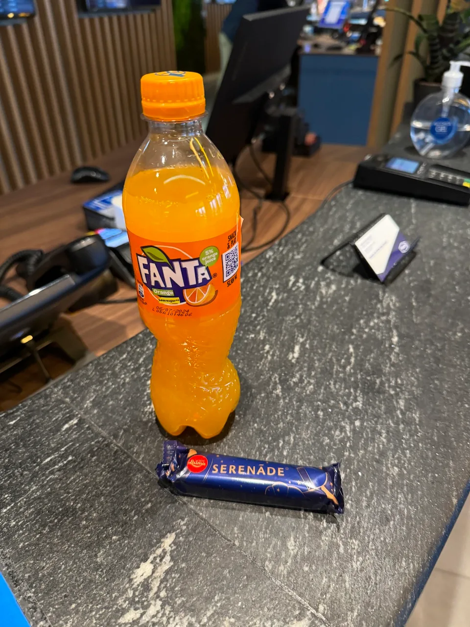 Flasche Fanta Orange auf Tisch neben Schokoriegel