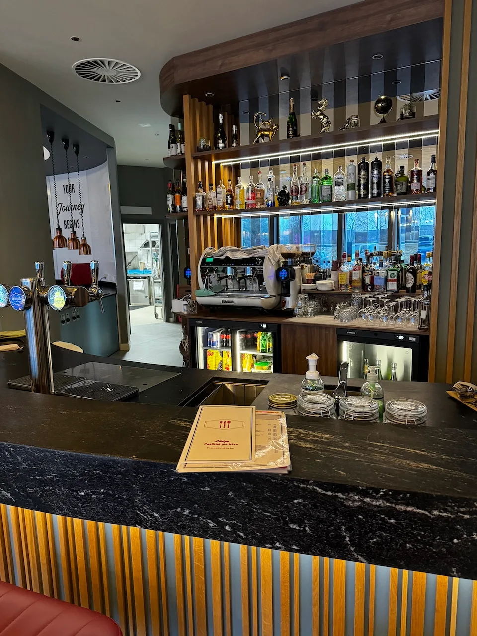 Bar mit Getränkeautomaten und Regal mit Flaschen
