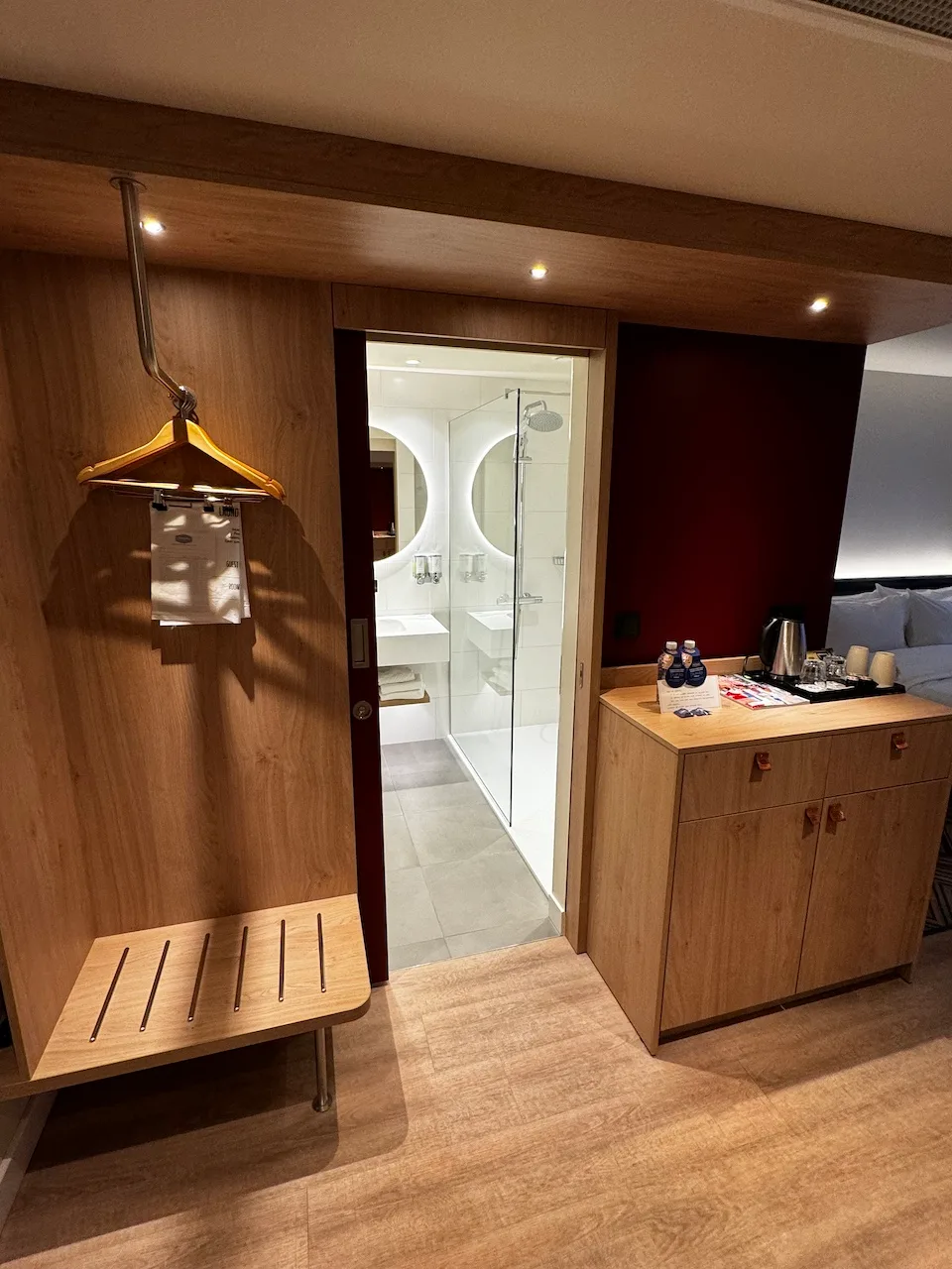 Hotelzimmer mit Garderobe und Badezimmer im Hintergrund