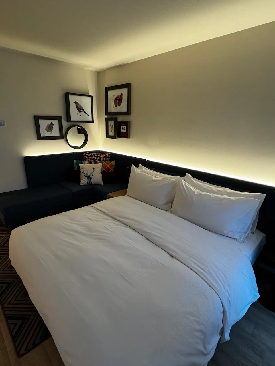 Hotelzimmer mit Doppelbett und dekorativer Wandgestaltung