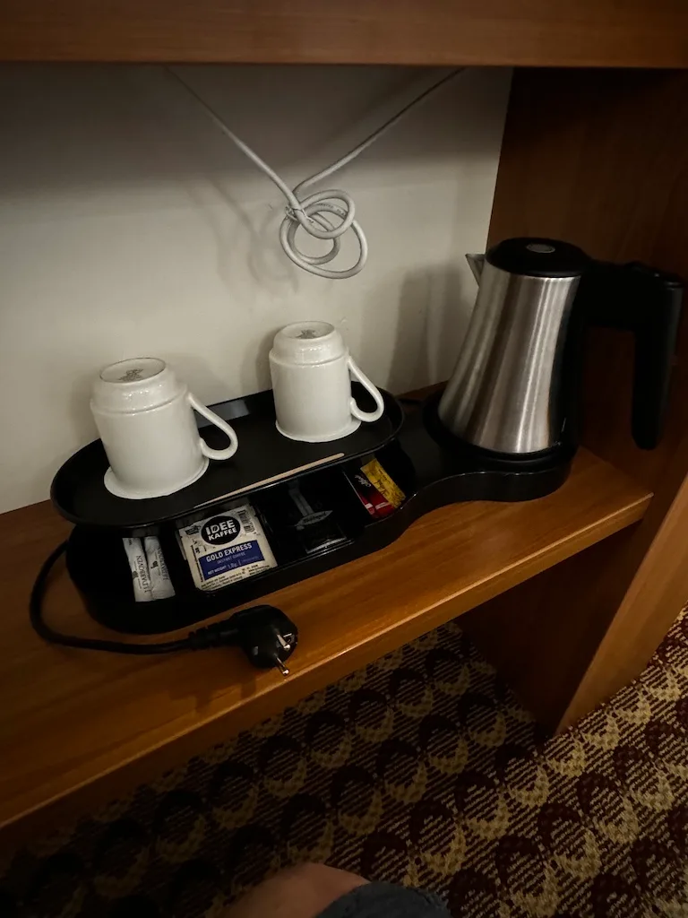 Hotelkaffeezubereitung mit Tassen und Kaffeekannen auf Schreibtisch