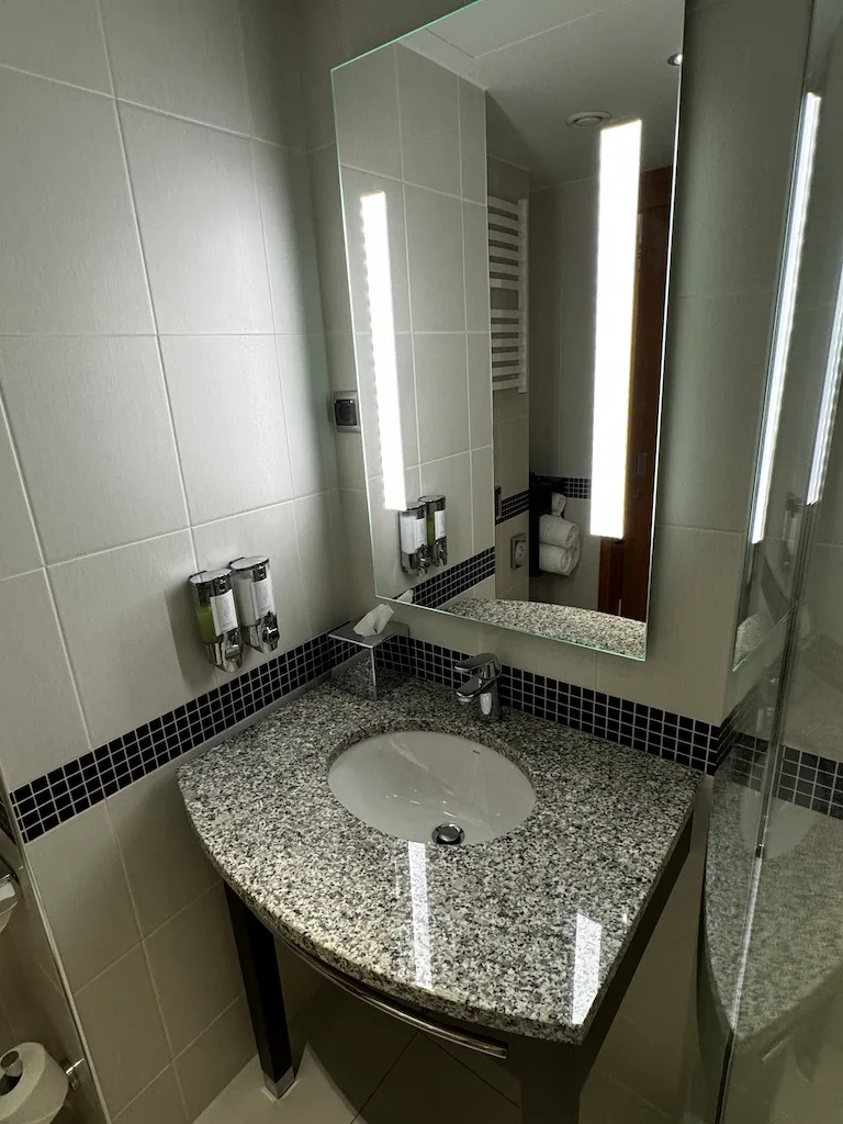 Hotelbadezimmer mit Granitwaschtisch und Spiegel