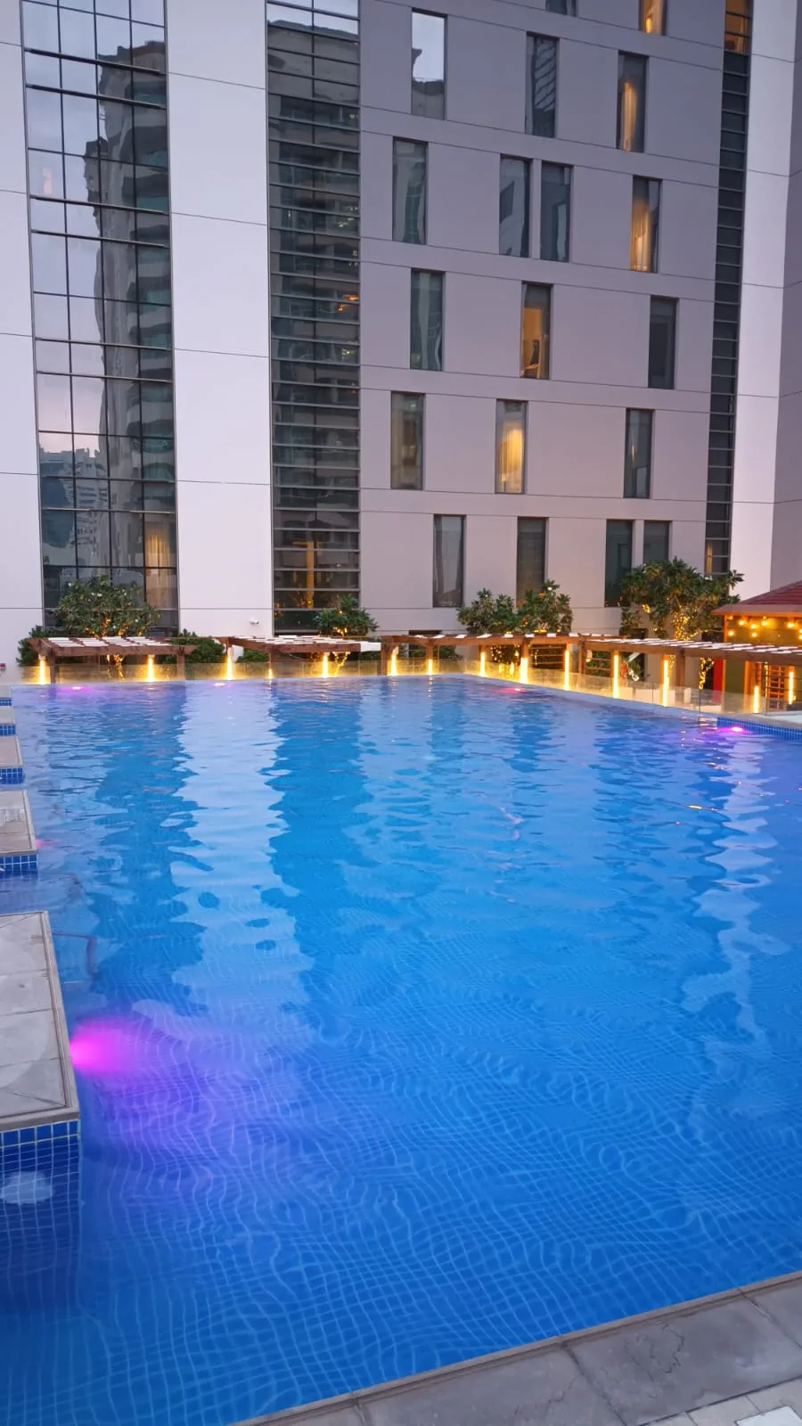 Außenansicht eines Hotels mit Pool bei Dämmerung