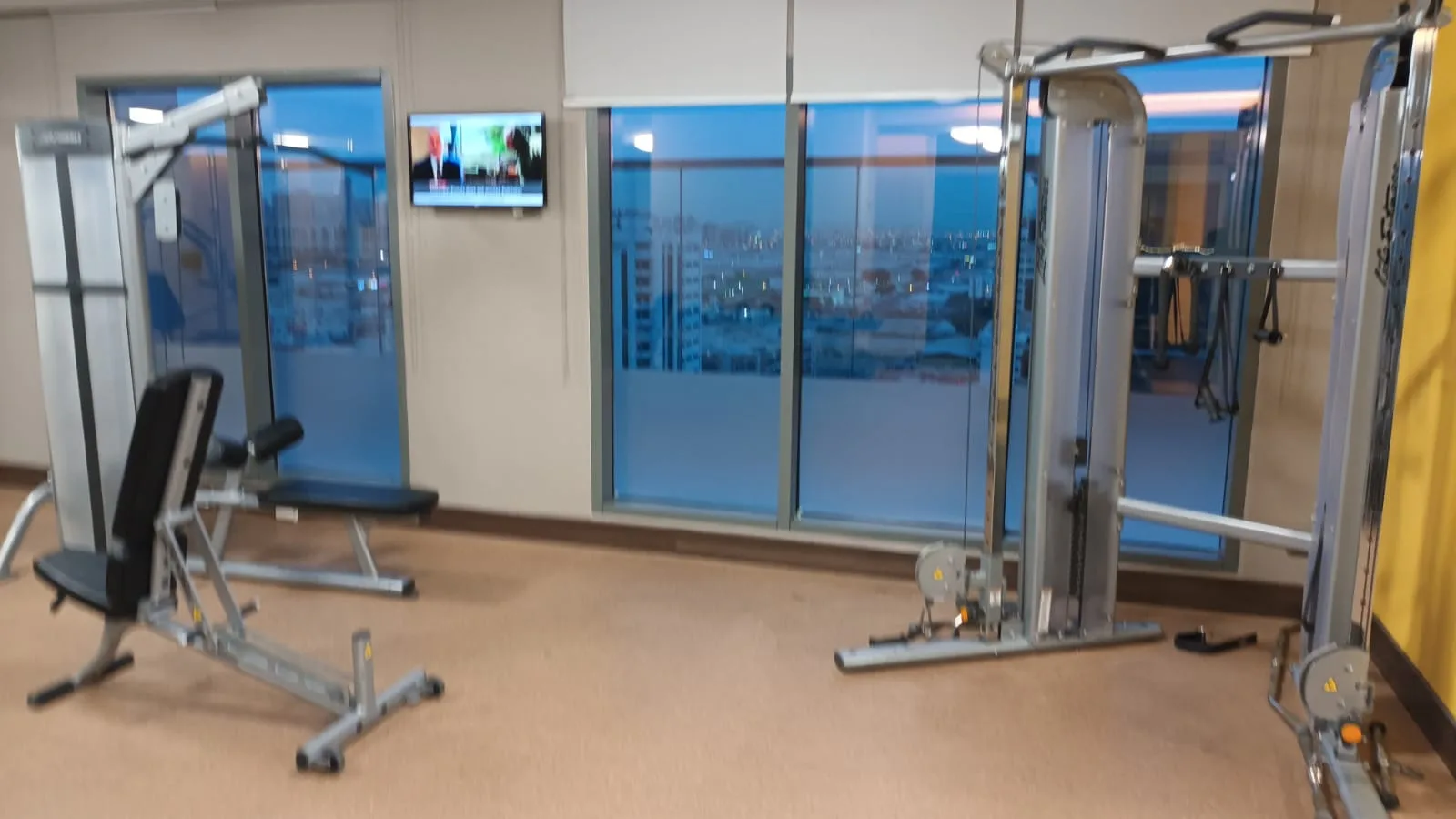 Fitnessraum mit Trainingsgeräten und Fernseher