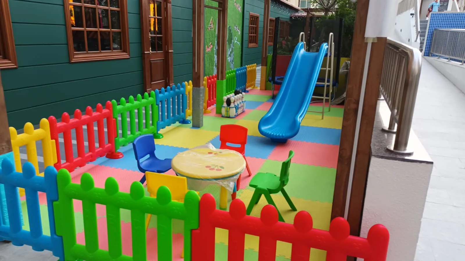 Kinderspielplatz mit buntem Zaun und Spielgeräten