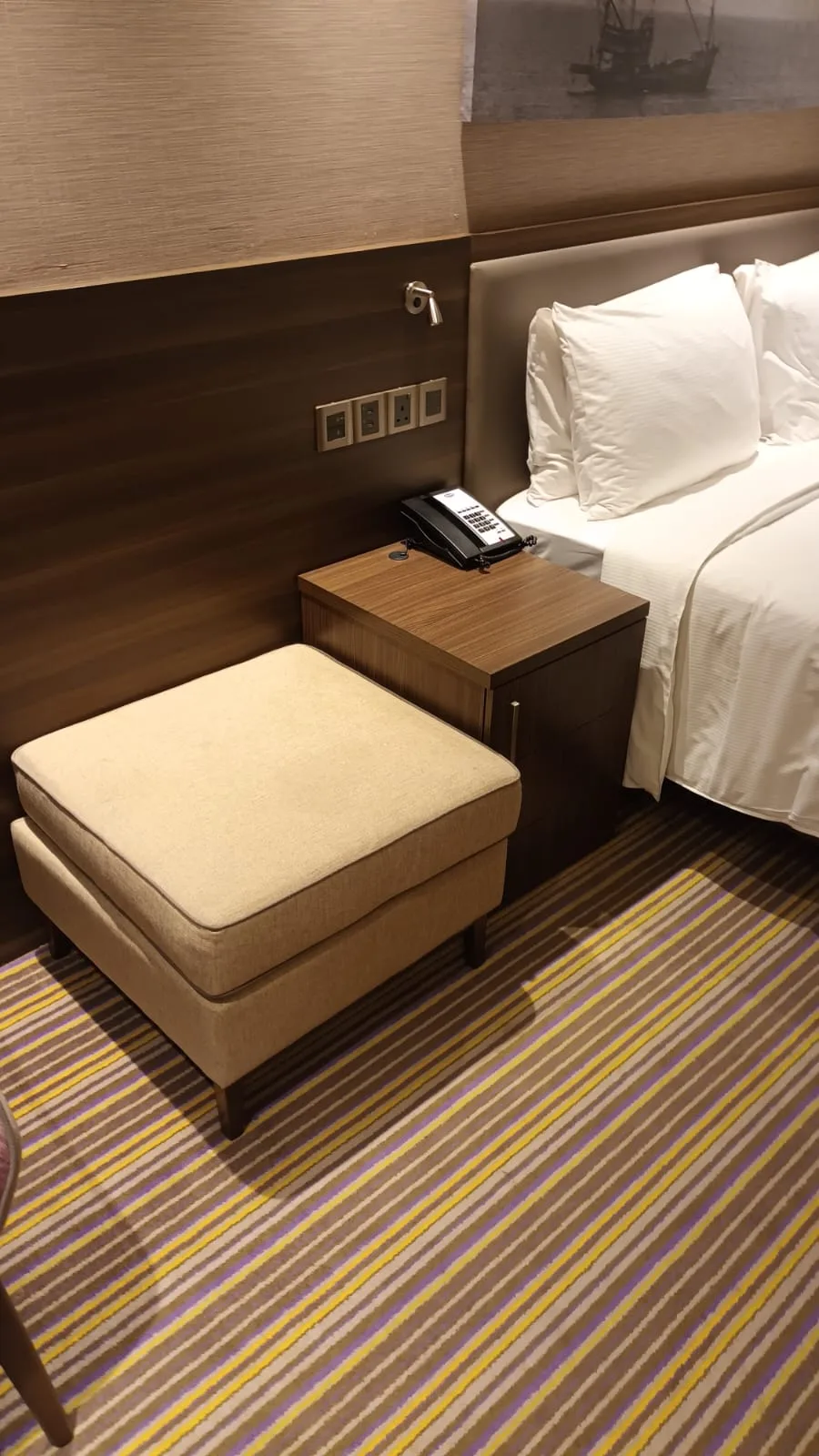 Hotelzimmer mit Doppelbett und Nachttisch