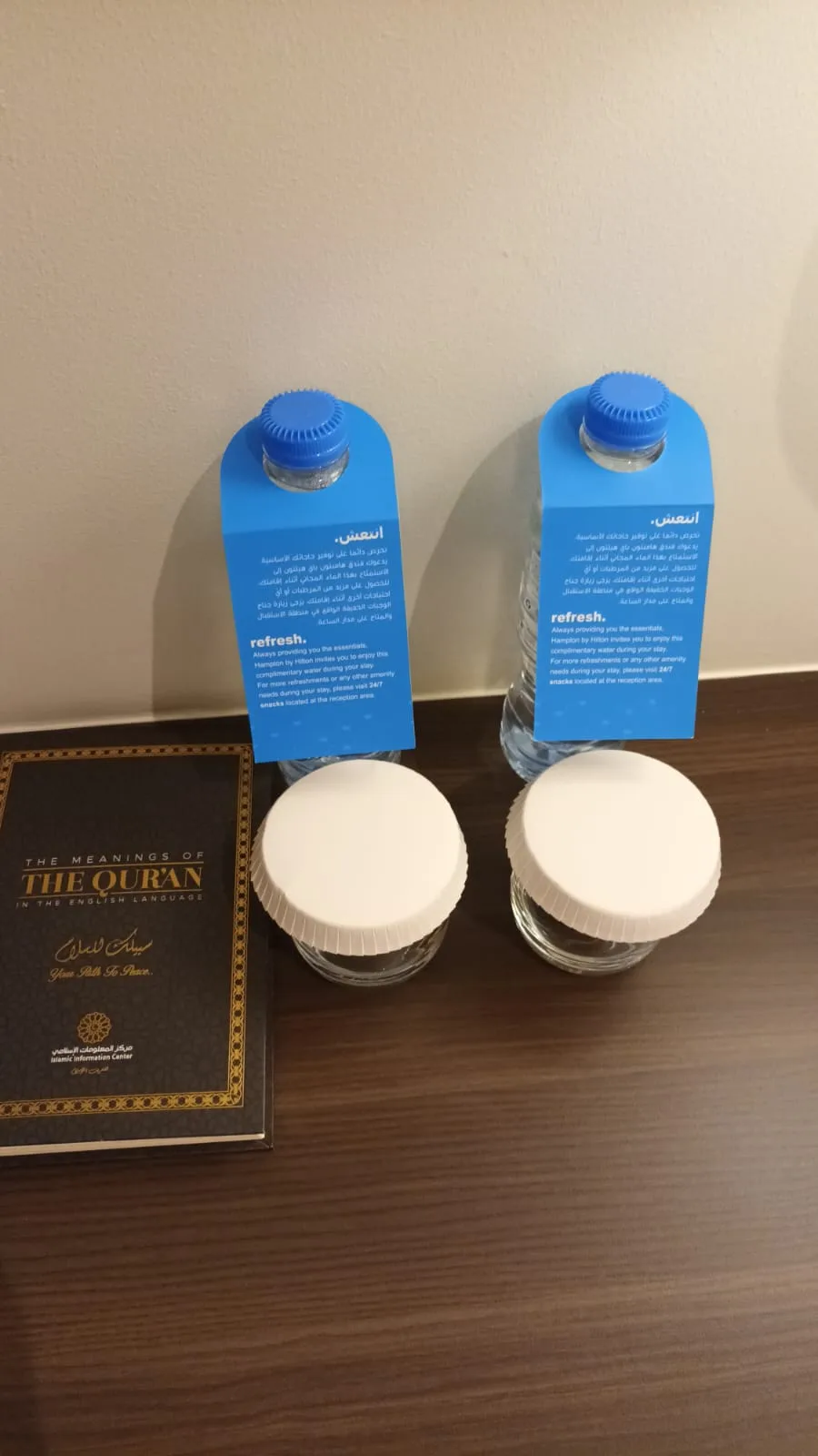 Flaschen mit Wasser und Flaschen mit Kaffee neben einem Buch über den Koran