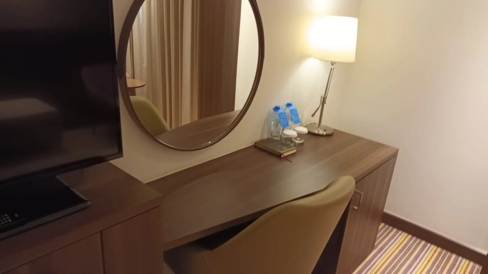 Hotelzimmer mit Schreibtisch, Spiegel und Lampe