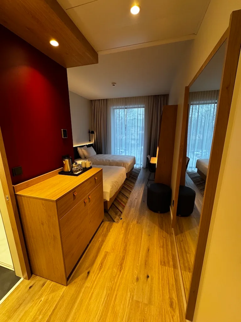 Hotelzimmer mit Doppelbetten und Holzmöbeln