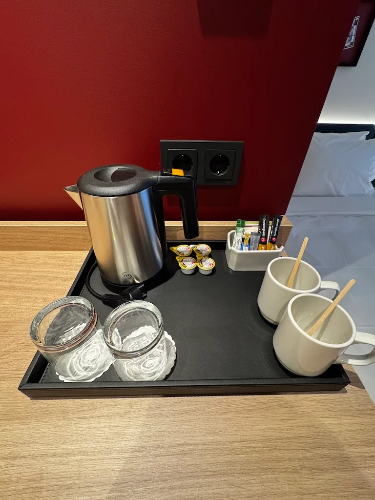 Hotelzimmertisch mit Kaffeemaschine, Gläsern und Tassen